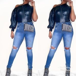 Asymmetrical leather look top with puff sleeve.